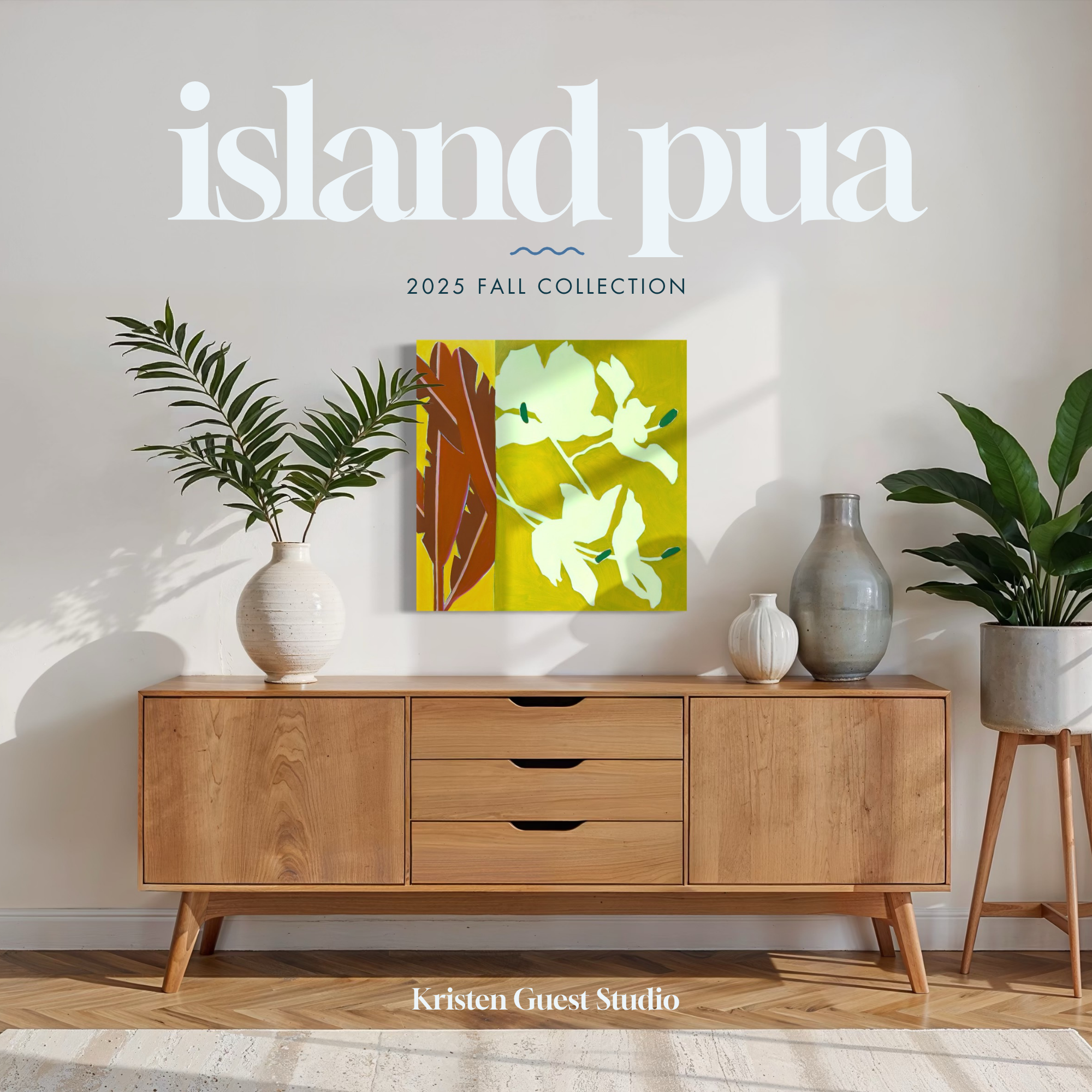 Studio wall display for 2025 fall collection with large typographic text, a framed artwork, and potted green plants on a light wood cabinet.
