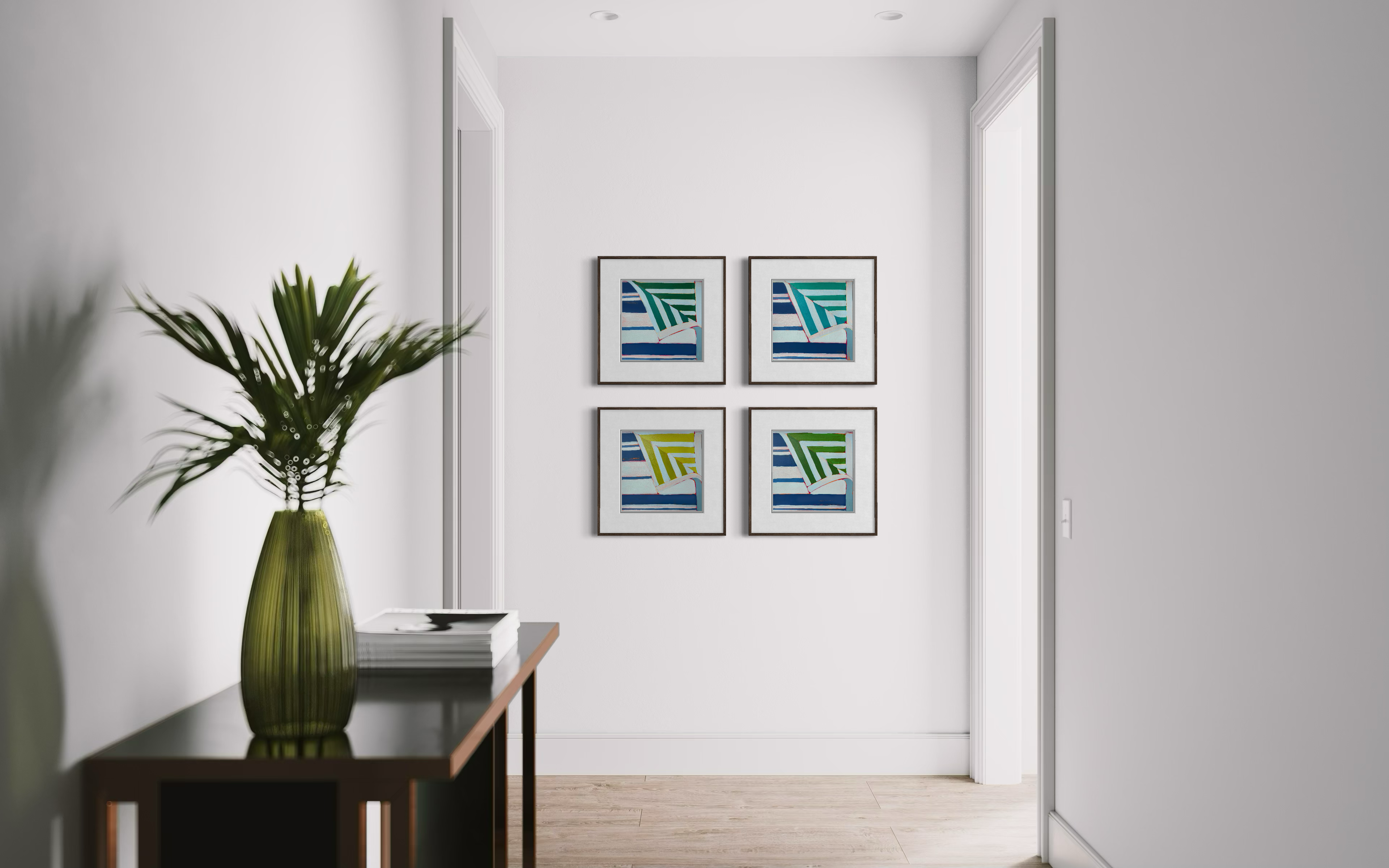 Hallway wall with four framed colorful sailboat artworks, pale doors and walls, and a tall green vase on a console table.